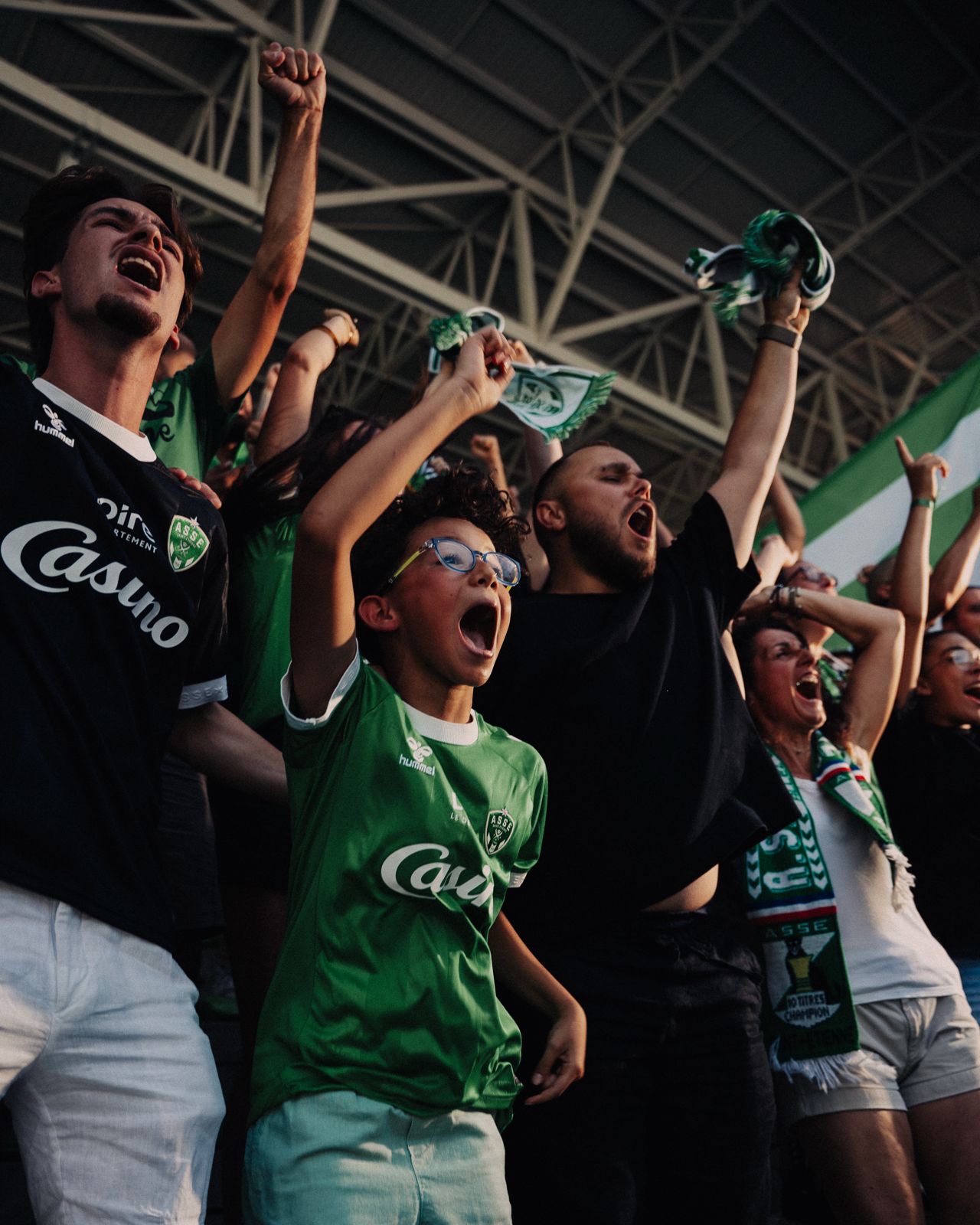 Supporters celebrating indoors, green jerseys