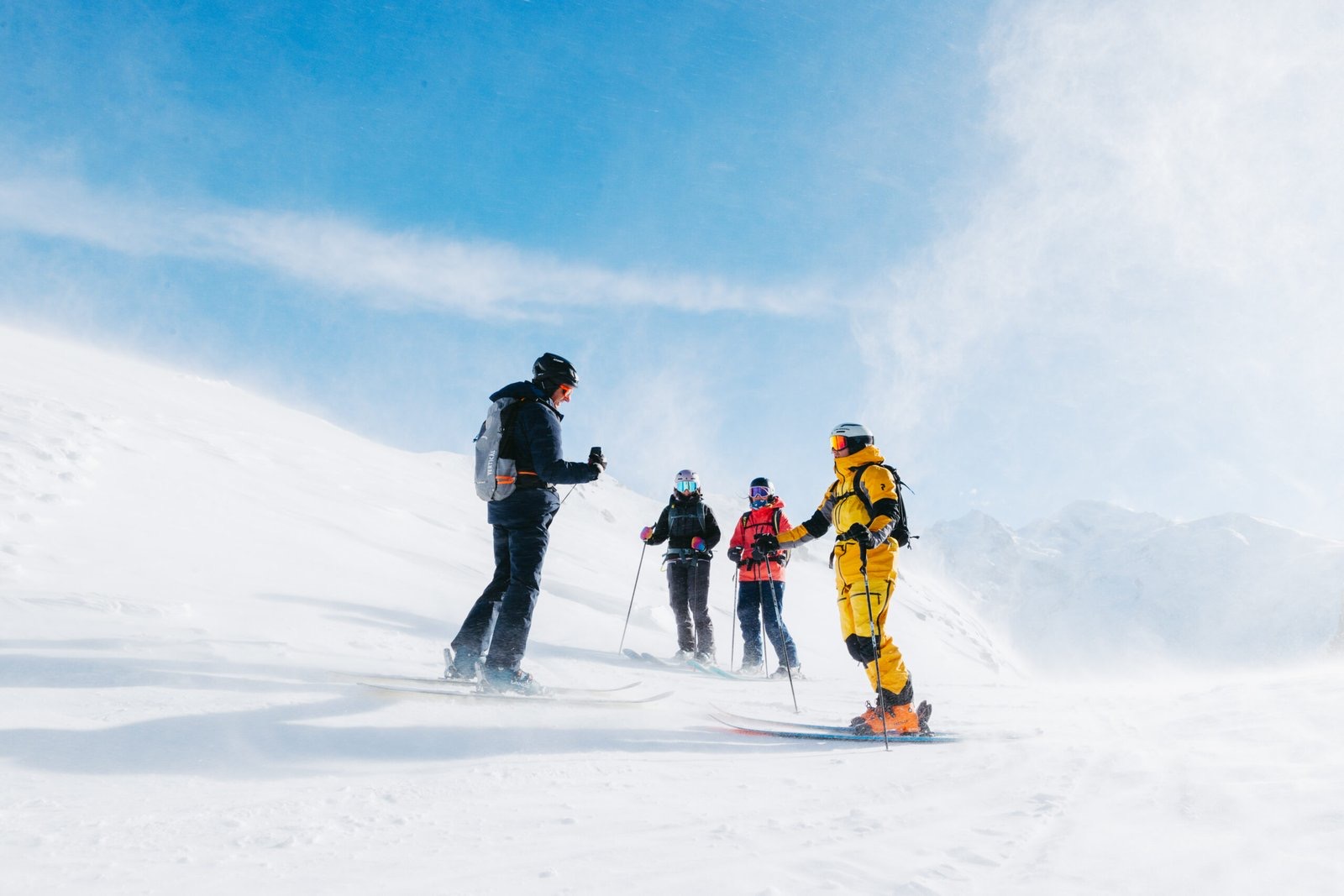 A group of off-piste skiers in blowing wind and snow